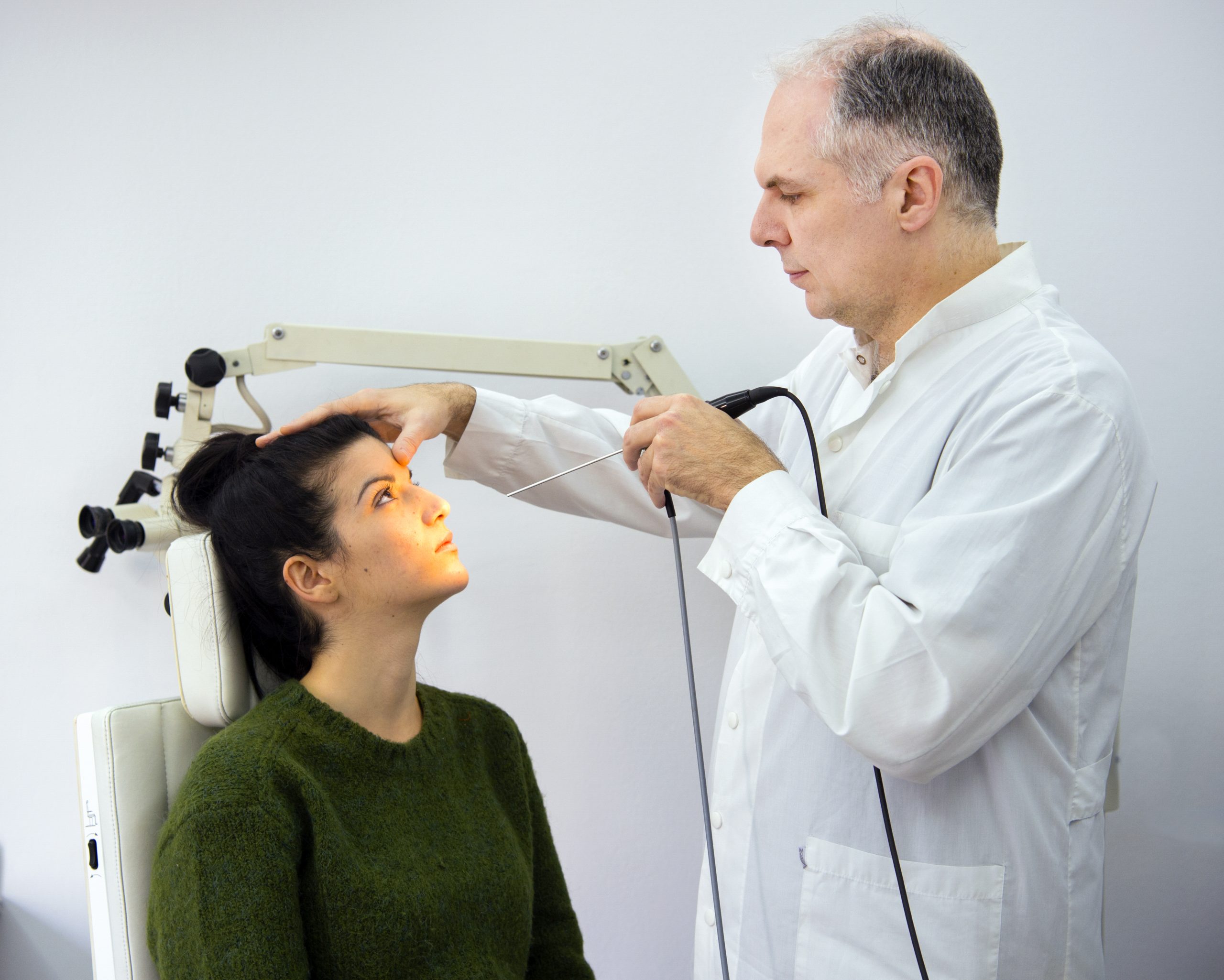 Dr George Mireas performing nasal examination and revision rhinoplasty assessment