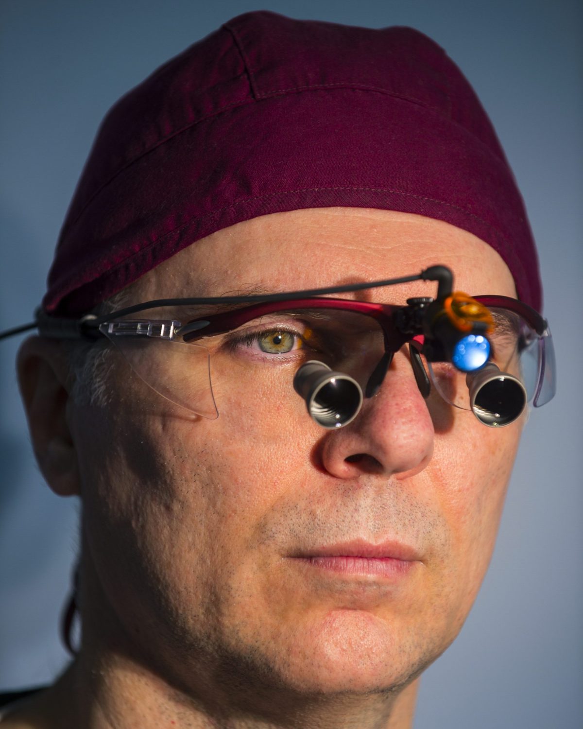 Dr George Mireas facial plastic surgeon wearing surgical loupes