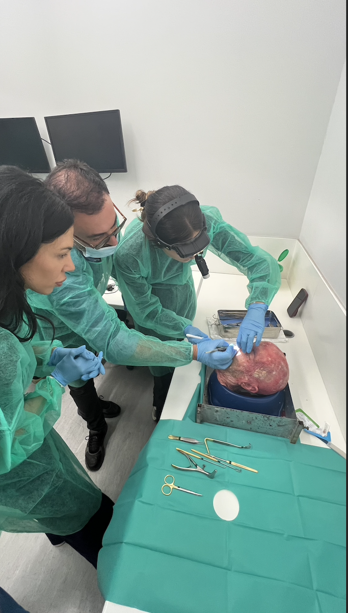 Small group practicing rhinoplasty cadaver techniques at workstation during HIFPS Athens 2025 course